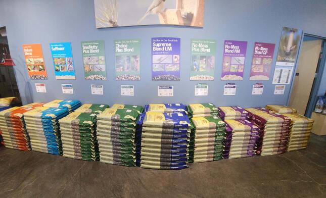 Neatly stacked bags of Wild Birds Unlimited bird-food blends displayed inside the Colorado Springs store